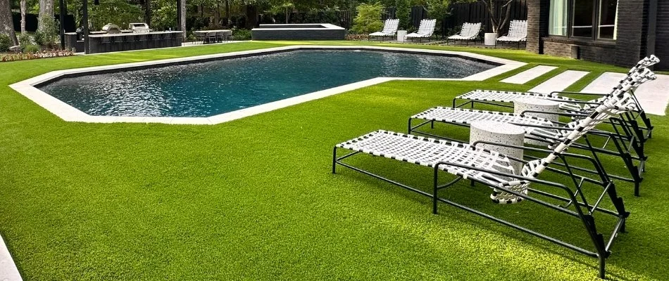 Outdoor space in Memphis, TN, with artificial turf, pool, and lounge chairs.