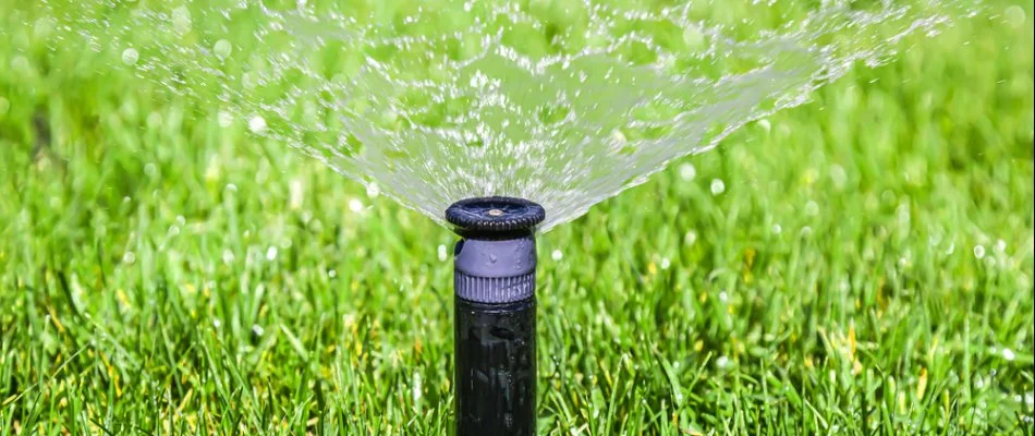 Sprinkler system spraying water on a lawn in Memphis, TN.